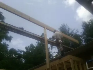 Carpenter setting a ridge beam over a new addition frame — Ice Dam Removal by Roofing Brothers in Haddam