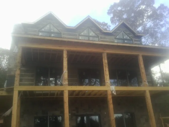 Dormers and porch framing on a large log home under construction — Roof Coating work by our crew in Haddam