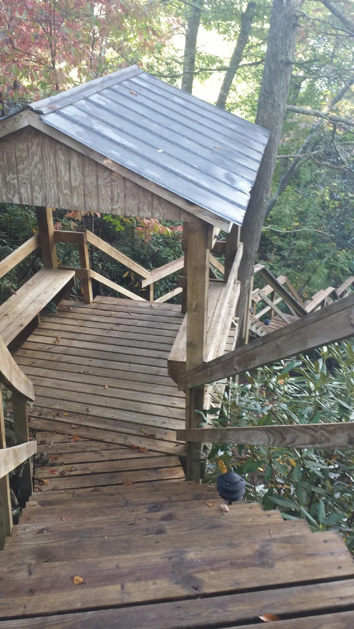 Metal roofed shelter over wooden steps on a wooded walkway — Skylight Repair & Installation work by our crew in Haddam