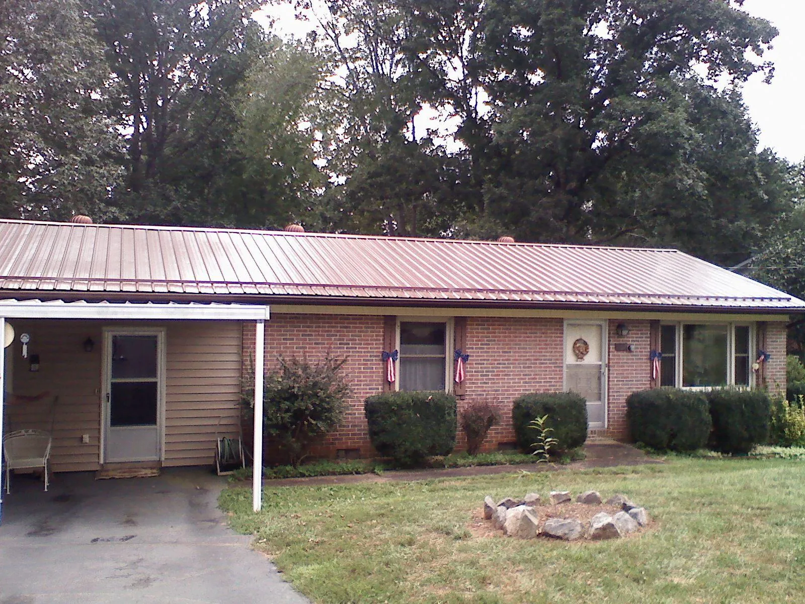 Bronze metal roof and carport on a brick ranch home — Roof Repair work by our crew in Haddam